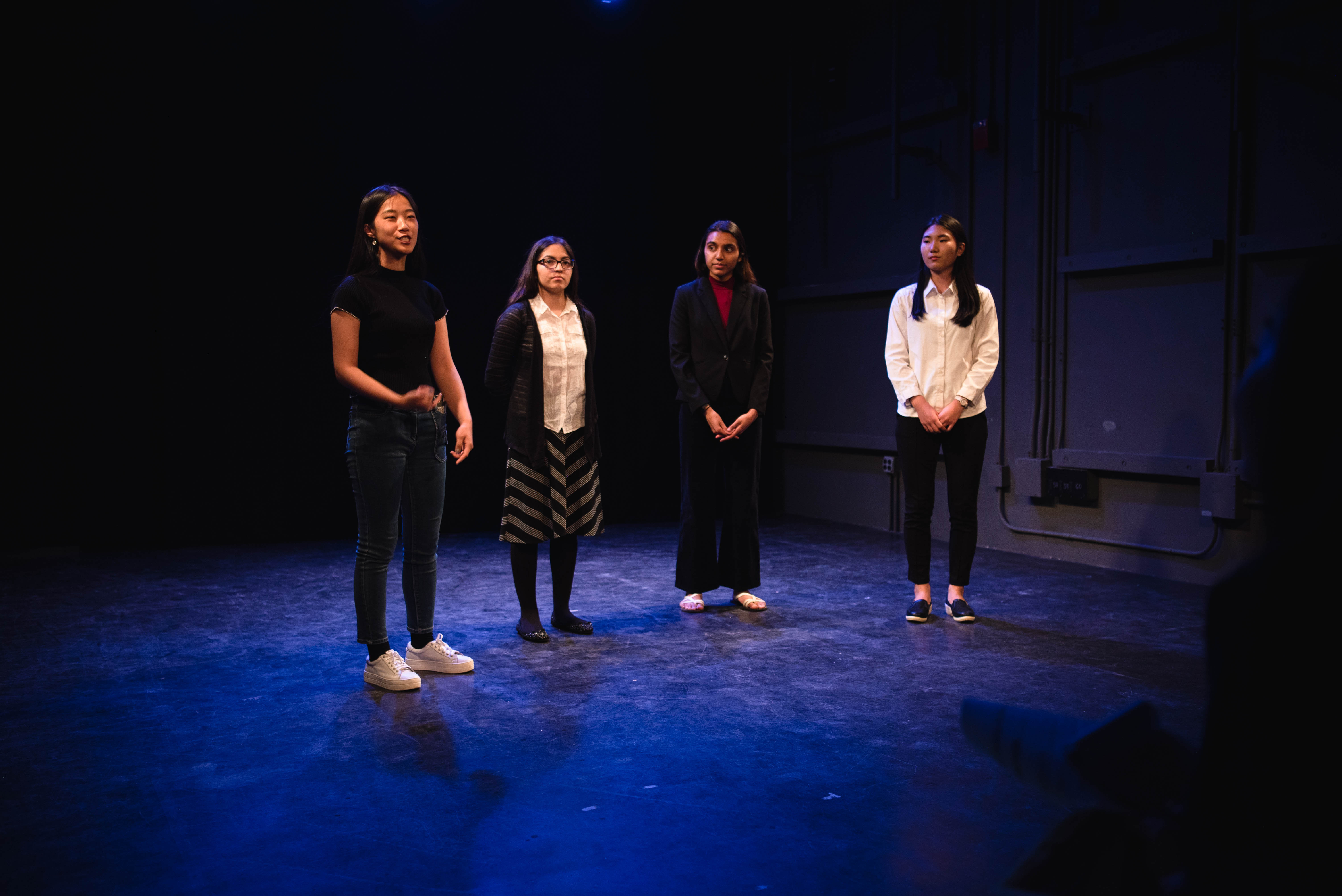 Four students present onstage