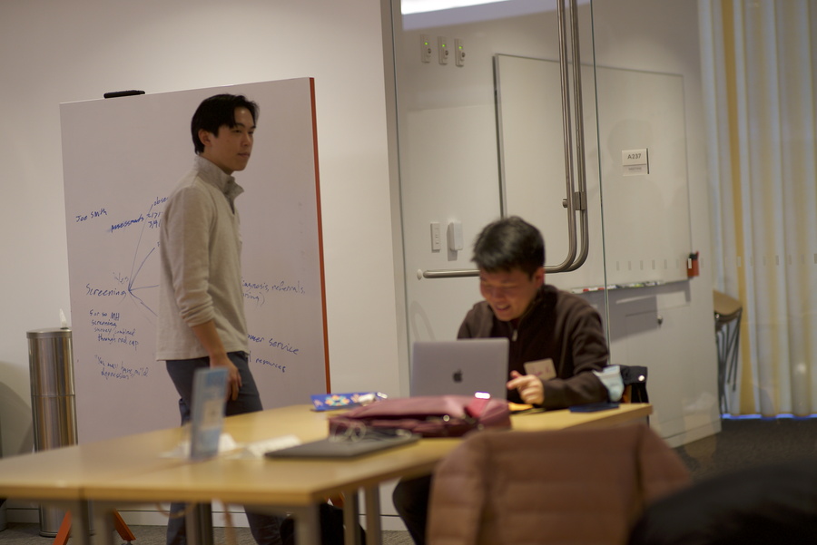 students on whiteboard while student is typing notes