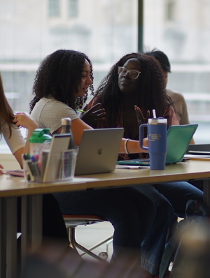 MiChaela Barker speaking with another female summer fellowship participant 