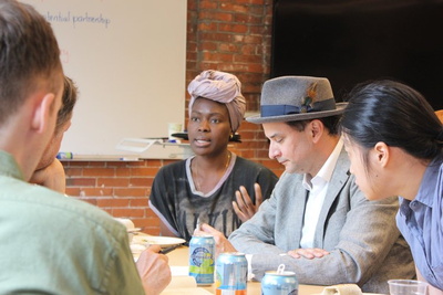 Siyonbola, center, speaks during a lunch with mentors