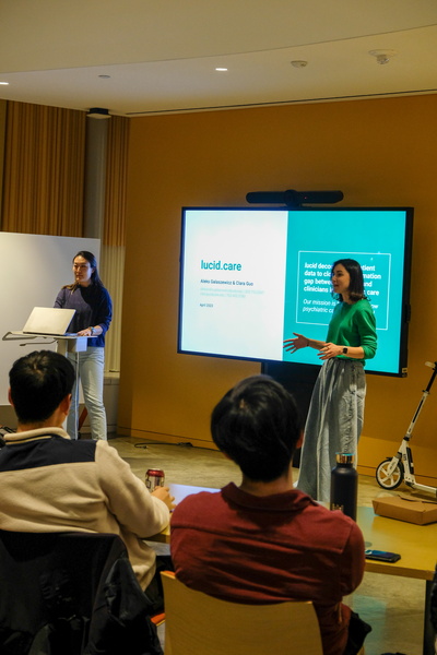 two women presenting a powerpoint in front of a crowd