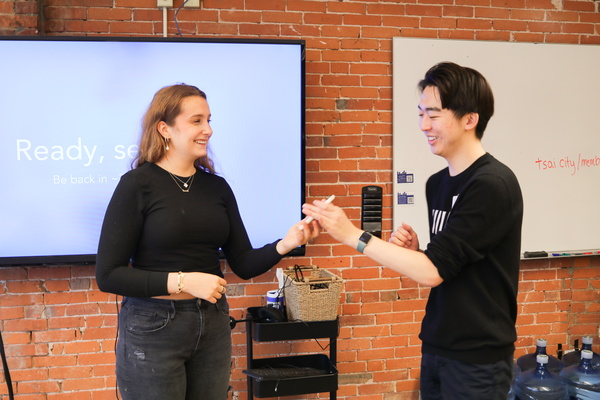 Two students laugh while holding phone