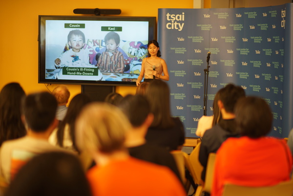 student pitching in front of Tsai CITY step and repeat