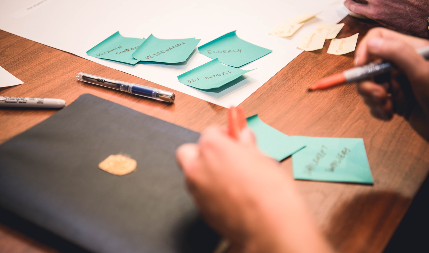 View of hands and post-its during brainstorm about potential customers