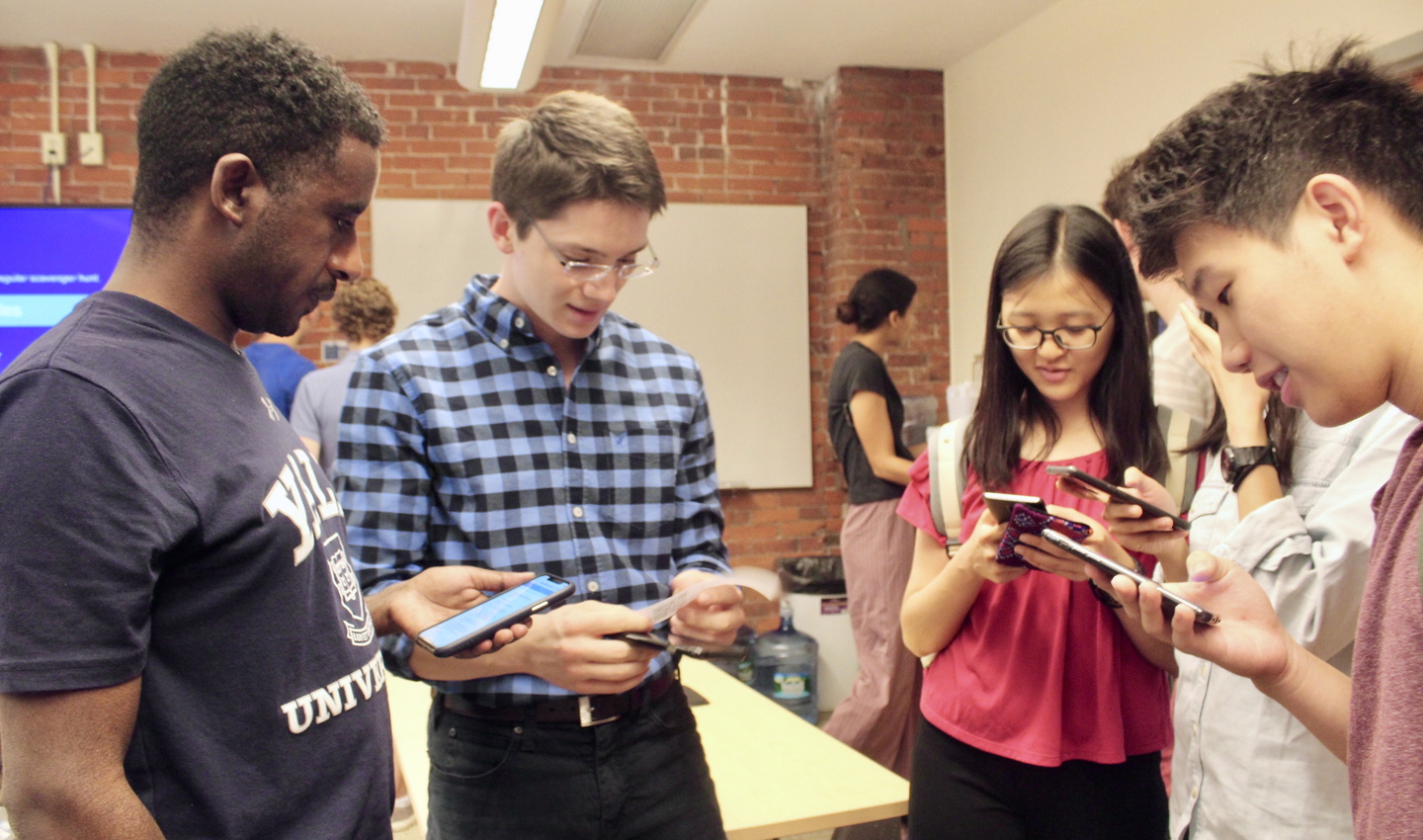 Four students look at phones