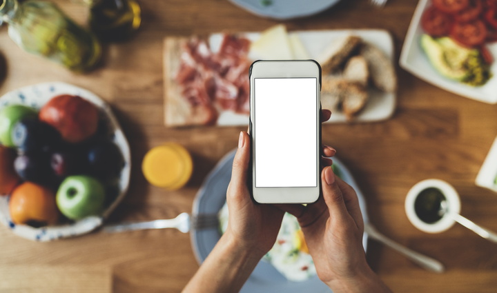 Smartphone over table full of food