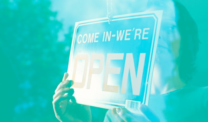 Illustration of person holding "Come in, we're open" sign