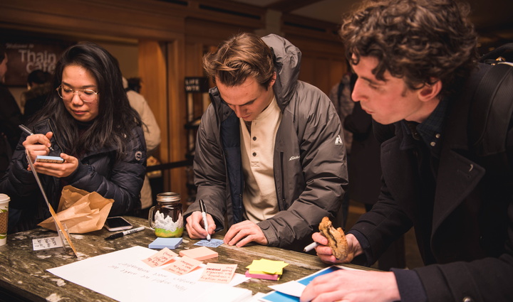 Students brainstorm around table