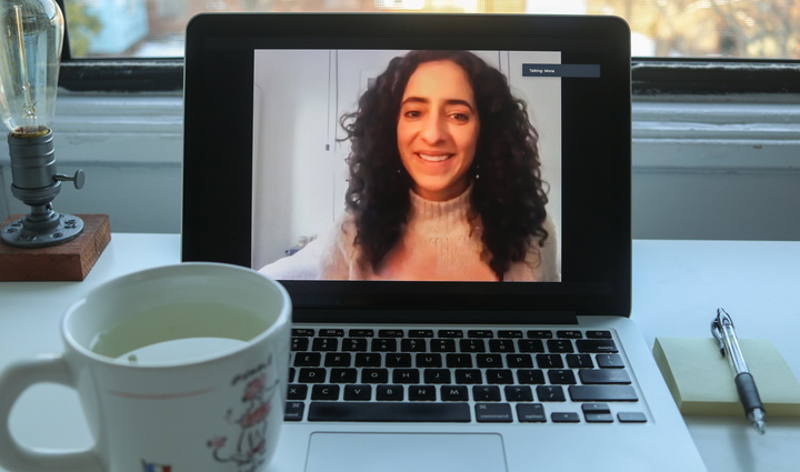 Image of laptop playing Mona Elsayed Zoom talk, on desk with tea and notebook