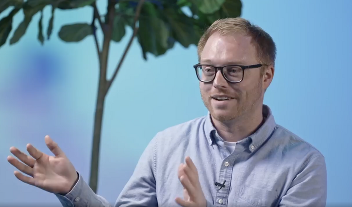 a person wearing glasses and a blue shirt