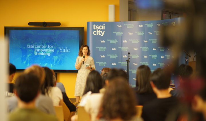 woman speaking with a microphone in front of an audience