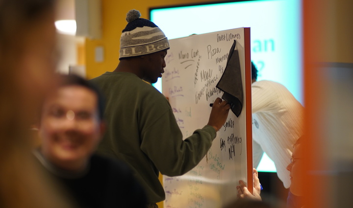 A man writing on a whiteboard, illustrating his ideas and thoughts.