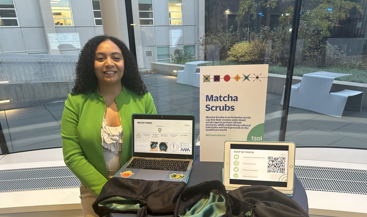 MiChaela Barker standing by a table showcasing her product