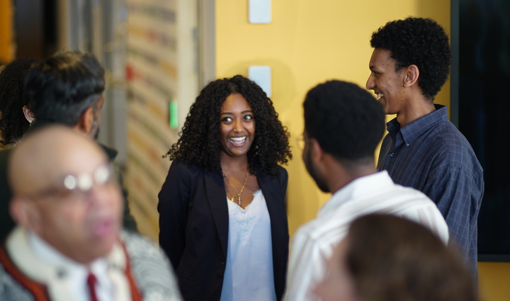  A group of people chatting in a hallway, engaged in lively conversation and enjoying each other's company
