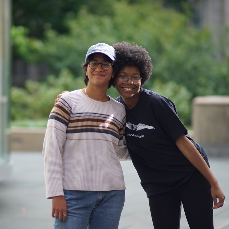 two students hugging and smiling at the camera