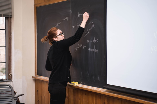 Instructor writes on chalkboard