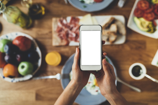 Smartphone over table full of food