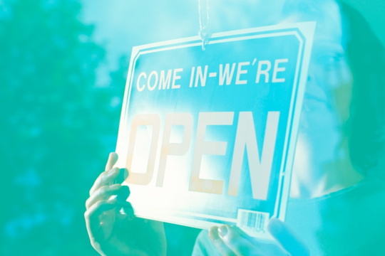 Illustration of person holding "Come in, we're open" sign