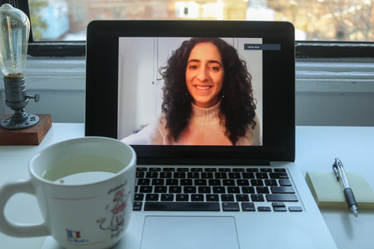 Image of laptop playing Mona Elsayed Zoom talk, on desk with tea and notebook