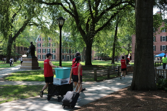 students moving luggage on Old Campus