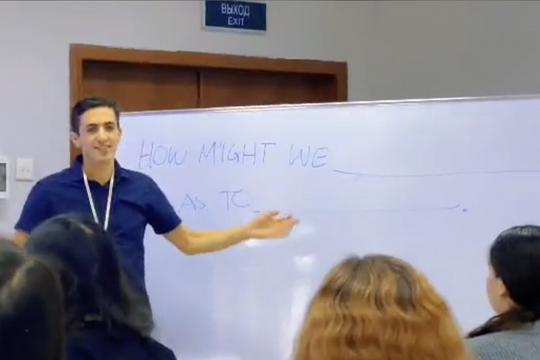 man teaching a class in front of a whiteboard 