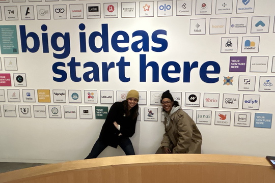 two people posing in front of a wall with the words "big ideas start here"