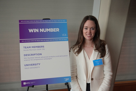 A woman poses in front of a poster with the text WIN NUMBER