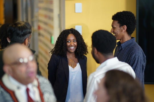  A group of people chatting in a hallway, engaged in lively conversation and enjoying each other's company